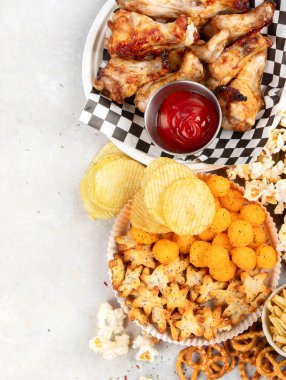 Çok çeşitli yemek ve fast food içeren masa sahnesi. Hamburger, pizza, kızarmış tavuk ve beyaz arka planda atıştırmalıklar. Üst Manzara. Boşluğu kopyala.