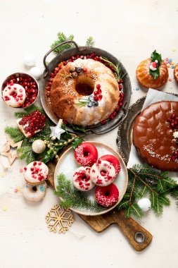 Beyaz arka planda çeşitli Noel tatlıları ve tatlılar. Üst Manzara. Pasta, çikolatalı pasta, kurabiye ve donut.