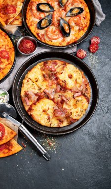 Siyah arka planda çeşitli İtalyan pizzaları, üst manzara..