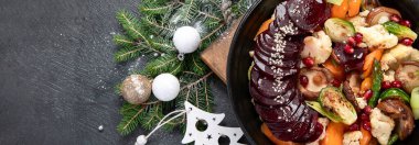 Fırınlanmış, kavrulmuş, tencerede kızartılmış sebzeler. Pancar, havuç, mantar, balkabağı ve Brüksel lahanası. Noel yemeği, vejetaryen Noel yemeği, üst manzara. Kopyalama alanı olan Panorama.