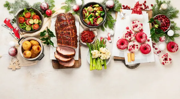 Concept of Christmas or New Year dinner with roasted meat and various vegetables dishes on a white background. Top view. Copy space.