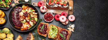 Brüksel lahanalı vejetaryen yemeği, havuç, karnabahar, mantar, avokado, koyu arka planda kek, üst manzara. Vejetaryen Noel yemeği, sağlıklı yemek..