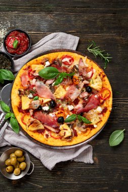 Lezzetli pizzalar yemeye hazır. Ev yapımı et severler Pepperoni ve pastırmalı pizza ahşap arka planda..