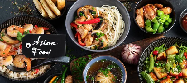 Asian food background with various ingredients on a black background, top view. Panorama, banner.