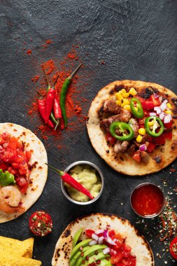 Salsa soslu taco, sebze ve siyah arka planda avokado. Üst görünüm, alanı kopyala.