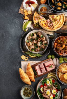 Karanlık arka planda Fransız yemek çeşitleri. Geleneksel mutfak konsepti. Üst Manzara. Boşluğu kopyala.