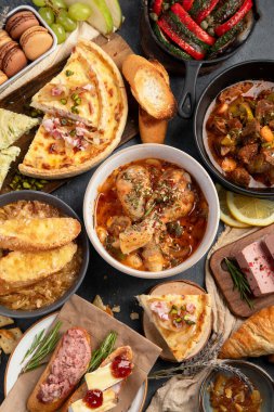 Karanlık arka planda Fransız yemek çeşitleri. Geleneksel mutfak konsepti. Üst görünüm.