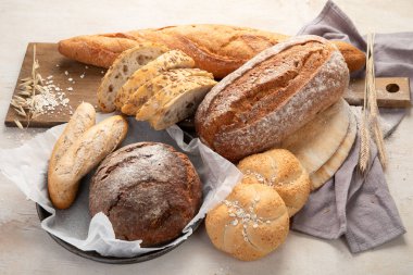 Beyaz arka planda çeşitli lezzetli taze pişmiş ekmek çeşitleri, üst manzara..