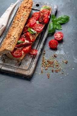 Caprese 'li taze ekmek. Domatesli lezzetli sandviç ve taze fesleğen yapraklı mozzarella peyniri. İtalyan gıda konsepti. Boşluğu kopyala.