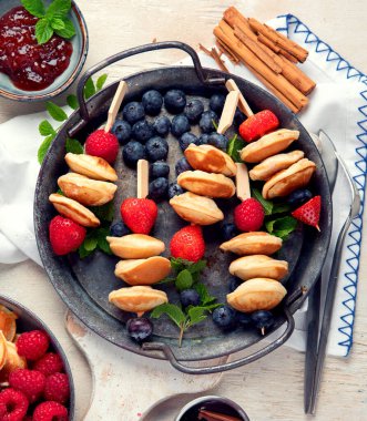 Yaban mersinli, çilekli ve ahududulu leziz krepler. Uzaktan kumandalı tatlı ve lezzetli bir kahvaltı. Üst görünüm.