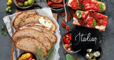 İtalyan antipasti aperatifleri. Peynirli lezzetli bruschettalar, güneşte kurutulmuş domatesler. Geleneksel gıda konsepti. Üst görünüm.