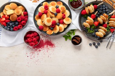 Yaban mersinli, çilekli ve ahududulu leziz krepler. Uzaktan kumandalı tatlı ve lezzetli bir kahvaltı. Üst görünüm, alanı kopyala.