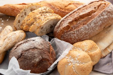 Beyaz arka planda çeşitli lezzetli taze pişmiş ekmek çeşitleri, üst manzara..