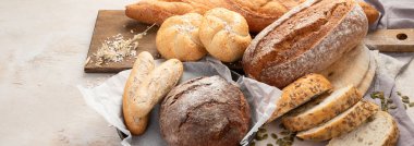 Beyaz arka planda çeşitli lezzetli taze pişmiş ekmek çeşitleri, üst manzara. Kopyalama alanı olan Panorama.