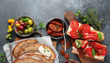 İtalyan antipasti aperatifleri. Peynirli lezzetli bruschettalar, güneşte kurutulmuş domatesler. Geleneksel gıda konsepti. Üst görünüm, alanı kopyala.