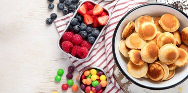 Kahvaltı ya da brunch. Beyaz arka planda çeşitli malzemelerle mini krepler. Üst görünüm.