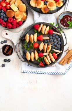 Yaban mersinli, çilekli ve ahududulu leziz krepler. Uzaktan kumandalı tatlı ve lezzetli bir kahvaltı. Üst görünüm, alanı kopyala.
