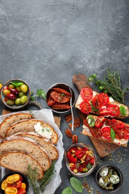 İtalyan antipasti aperatifleri. Peynirli lezzetli bruschettalar, güneşte kurutulmuş domatesler. Geleneksel gıda konsepti. Üst görünüm, alanı kopyala.