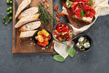 İtalyan antipasti aperatifleri. Peynirli lezzetli bruschettalar, güneşte kurutulmuş domatesler. Geleneksel gıda konsepti. Üst görünüm, alanı kopyala.
