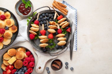 Yaban mersinli, çilekli ve ahududulu leziz krepler. Uzaktan kumandalı tatlı ve lezzetli bir kahvaltı. Üst görünüm, alanı kopyala.