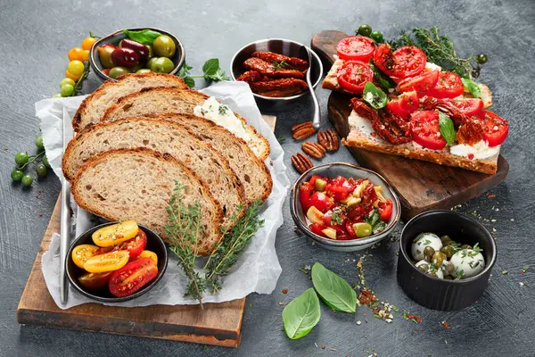 İtalyan antipasti aperatifleri. Peynirli lezzetli bruschettalar, güneşte kurutulmuş domatesler. Geleneksel gıda konsepti. 