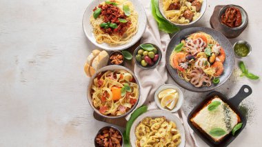 Açık deniz kenarında İtalyan makarna tabakları. Geleneksel gıda konsepti. Üst görünüm, alanı kopyala.