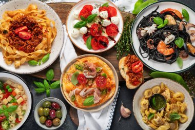 Koyu arka planda İtalyan yemekleri. Geleneksel gıda konsepti. Üst görünüm.