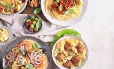 Açık deniz kenarında İtalyan makarna tabakları. Geleneksel gıda konsepti. Üst görünüm, alanı kopyala