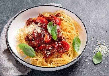 Lezzetli iştah açıcı klasik İtalyan spagetti bolonez makarnası domates soslu, peynirli parmesan peyniri, et ve fesleğen. Üst görünüm.
