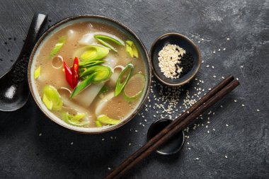 Arka planda kırmızı biberli bir kase pırasa çorbası. Yemek konsepti. Üst görünüm.