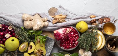 Bağışıklığı arttıran gıdaların çeşitliliği. Zencefil, zerdeçal, narenciye, otlar, beyaz arka planda sarımsak, üst manzara. Sağlıklı, vejetaryen virüsü bileşenleri yener, kopyalama alanı olan panorama.