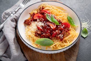 Lezzetli iştah açıcı klasik İtalyan spagetti bolonez makarnası domates soslu, peynirli parmesan peyniri, et ve fesleğen. Üst görünüm.