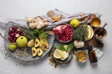 Bağışıklığı arttıran gıdaların çeşitliliği. Zencefil, zerdeçal, narenciye, otlar, beyaz arka planda sarımsak, üst manzara. Sağlıklı, vegan virüs bileşenleri yeniyor.