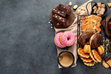 Lezzetli kurabiyeli beyaz kahve, çörek, kek, şeker, waffle. Karanlık arka planda şekerli sıcak içecek. Üst görünüm, alanı kopyala.