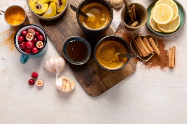 İçinde limon, zencefil, tarçın çubuğu ve bal bulunan beyaz arka planda bulunan sağlıklı zerdeçal çayı. Bağışıklık güçlendirici ilaç. Boşluğu kopyala.