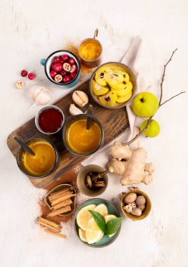 İçinde limon, zencefil, tarçın çubuğu ve bal bulunan beyaz arka planda bulunan sağlıklı zerdeçal çayı. Bağışıklık güçlendirici ilaç.