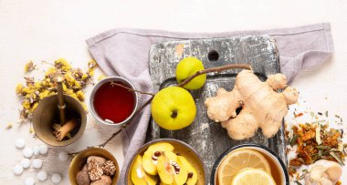 Soğuk algınlığı ve grip virüsü için doğal şifalı bitkisel ilaç. Taze zencefil, limon, bal ve tarçınla birlikte sıcak içecek. Beyaz arka planda ekinezya, dikenli çilek ve ginseng. Bağışıklık güçlendirici. Boşluğu kopyala.