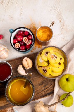 İçinde limon, zencefil, tarçın çubuğu ve bal bulunan beyaz arka planda bulunan sağlıklı zerdeçal çayı. Bağışıklık güçlendirici ilaç.