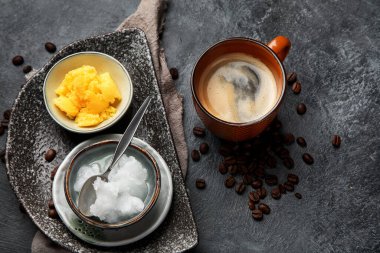 Kurşun geçirmez keto kahvesi. Ketogenik diyet. Hindistan cevizi yağı ve koyu arkaplanda yağ ile sıcak kurutma. Üst görünüm