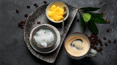 Kurşun geçirmez keto kahvesi. Ketogenik diyet. Hindistan cevizi yağı ve koyu arkaplanda yağ ile sıcak kurutma. Üst görünüm