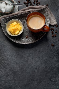 Kurşun geçirmez keto kahvesi. Ketogenik diyet. Hindistan cevizi yağı ve koyu arkaplanda yağ ile sıcak kurutma. Üst görünüm, alanı kopyala