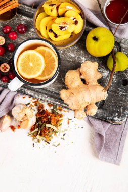 Soğuk algınlığı ve grip virüsü için doğal şifalı bitkisel ilaç. Taze zencefil, limon, bal ve tarçınla birlikte sıcak içecek. Beyaz arka planda ekinezya, dikenli çilek ve ginseng. Bağışıklık güçlendirici. Boşluğu kopyala.