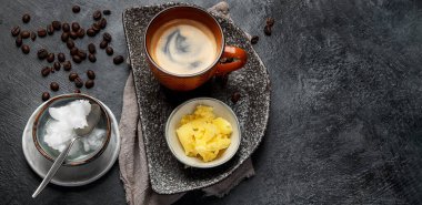 Kurşun geçirmez keto kahvesi. Ketogenik diyet. Hindistan cevizi yağı ve koyu arkaplanda yağ ile sıcak kurutma. Üst görünüm, pankart, kopyalama alanı