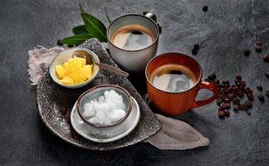 Kurşun geçirmez keto kahvesi. Ketogenik diyet. Hindistan cevizi yağı ve koyu arkaplanda yağ ile sıcak kurutma. 