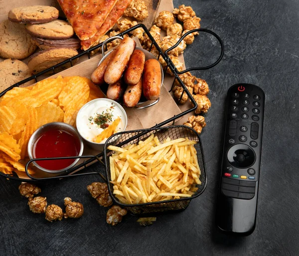 Unhealthy Food Basket Remote Control Snacks Chips Popcorn Cookies Cheese — Stock Photo, Image
