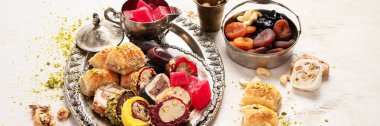 Baklava, halva, rahat lokum, fındık, fıstık, hurma, kuru üzüm, kayısı, kilise. Geleneksel doğu tatlıları, Arap tatlıları, beyaz arka planda Türk tatlıları. Üst Manzara. Panorama.