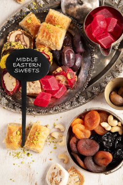 Baklava, halva, rahat lokum, fındık, fıstık, hurma, kuru üzüm, kayısı, kilise. Geleneksel doğu tatlıları, Arap tatlıları, beyaz arka planda Türk tatlıları. Üst görünüm. 