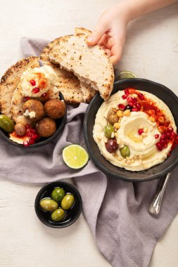 Bir kase kızarmış falafel, pide ve humus sosu. Orta Doğu mutfağında hafif bir arka planda atıştırmalık. Üst görünüm.