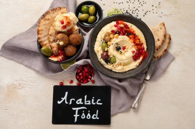 Bir kase kızarmış falafel, pide ve humus sosu. Orta Doğu mutfağında hafif bir arka planda atıştırmalık. Üst görünüm.