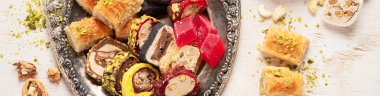 Baklava, halva, rahat lokum, fındık, fıstık, hurma, kuru üzüm, kayısı, kilise. Geleneksel doğu tatlıları, Arap tatlıları, beyaz arka planda Türk tatlıları. Üst Manzara. Kopyalama alanı olan Panorama.
